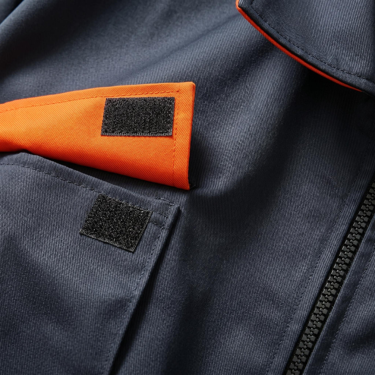 Dark blue work coverall chest detail with orange collar and pocket