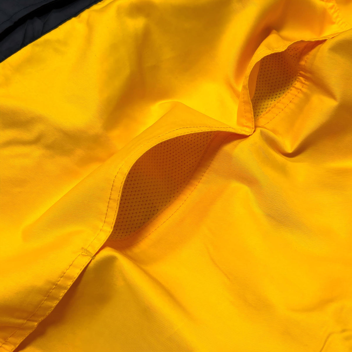 Close-up of yellow garment pocket and mesh lining.