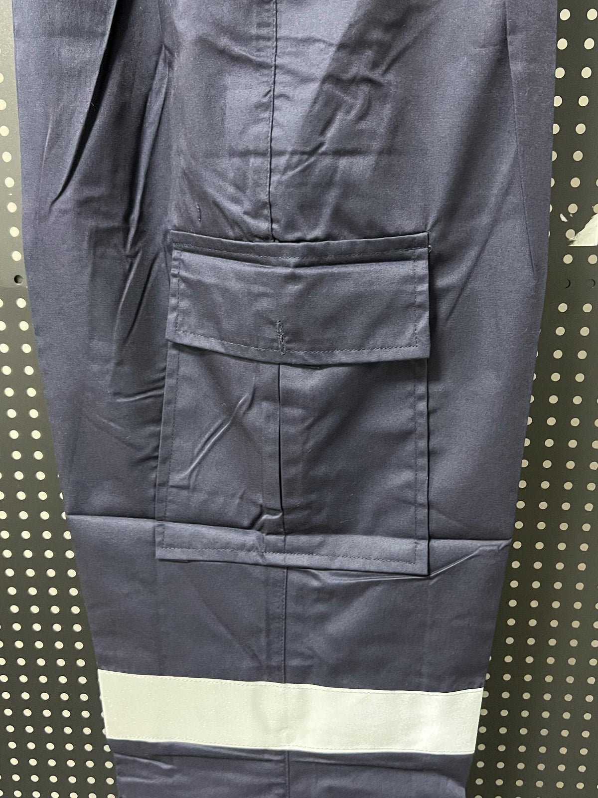 Navy cargo trousers pocket and reflective leg band detail.