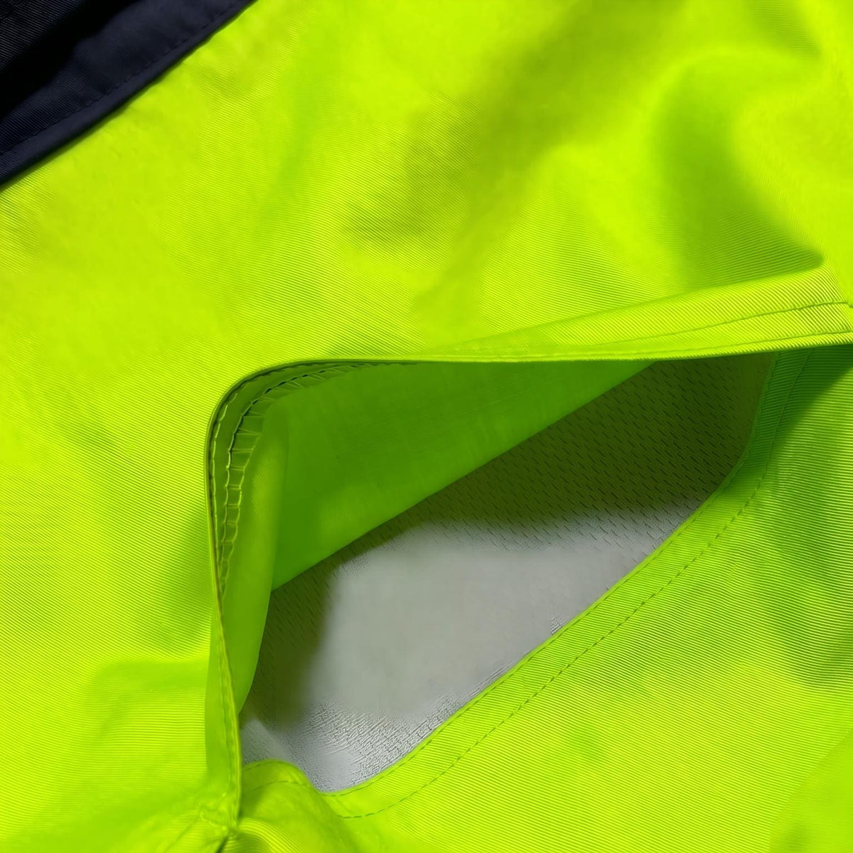 Neon yellow/navy jacket pocket detail with lining.