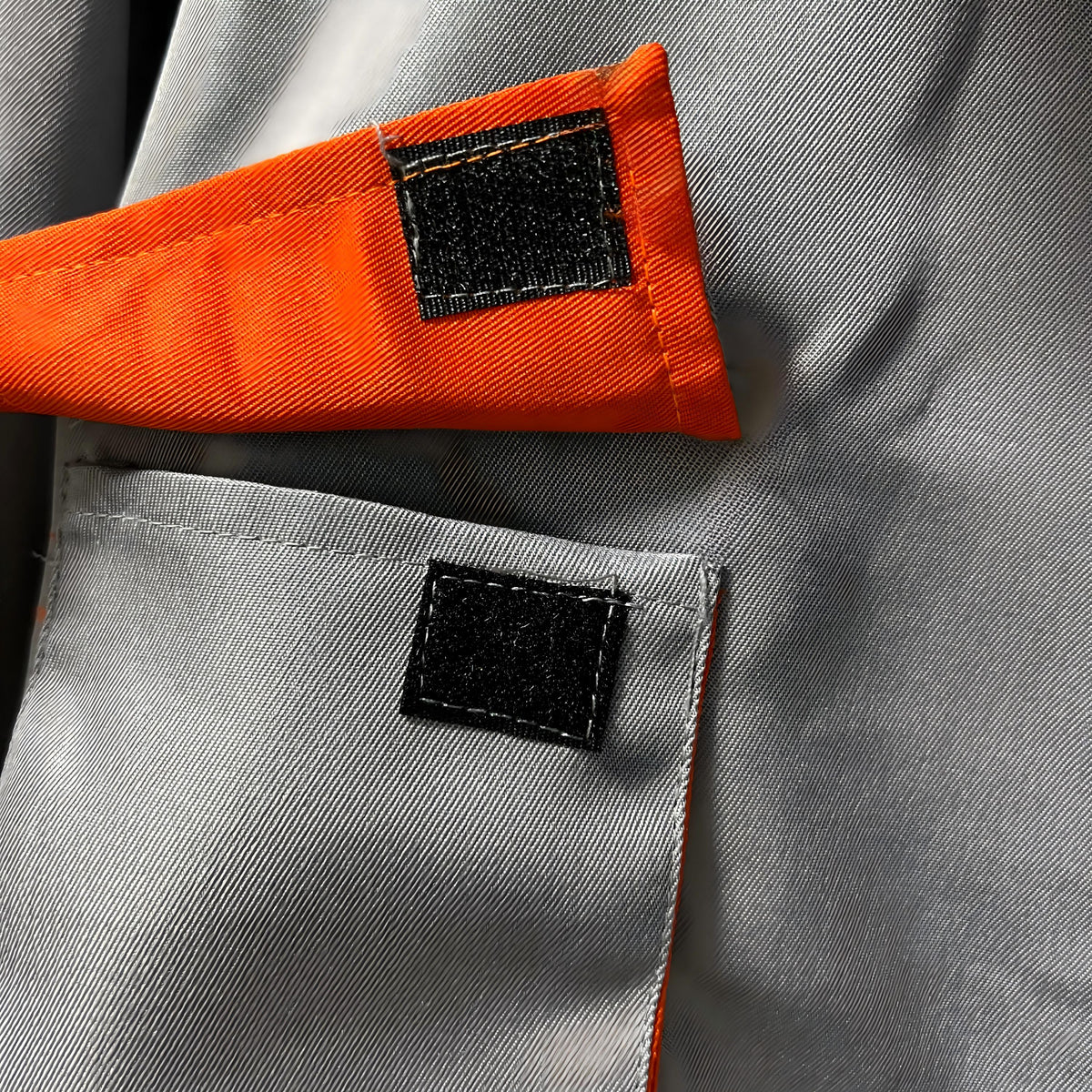 Light gray coverall pocket detail with orange flap
