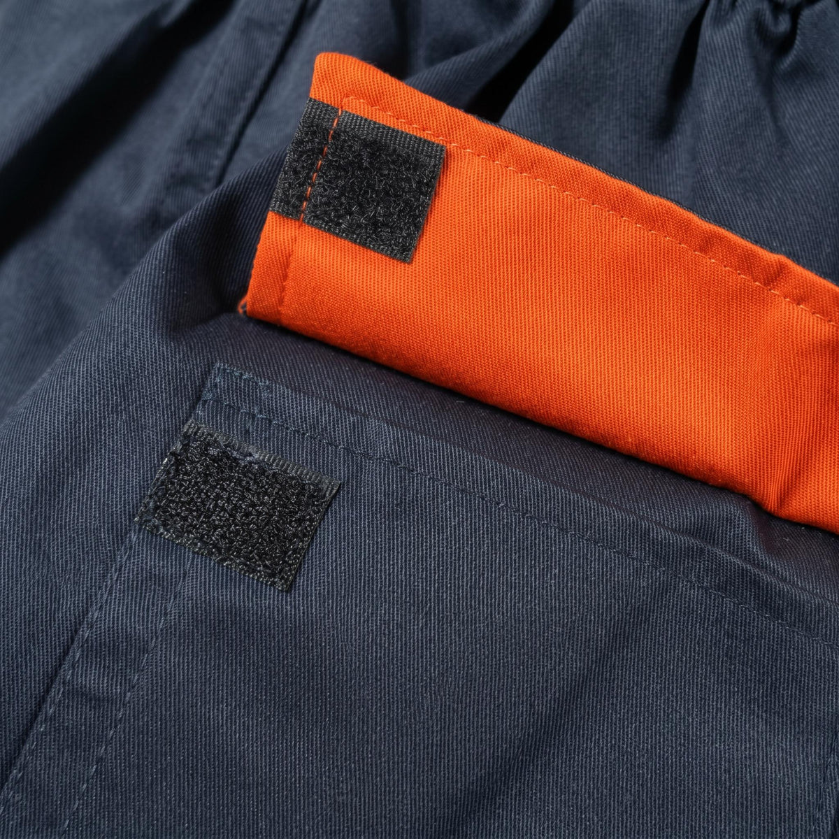 Navy blue coverall pocket detail with orange flap