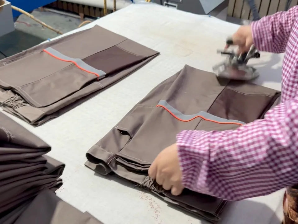 Workwear garment being pressed during finishing