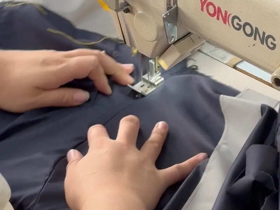 Garment panels being stitched at a sewing machine